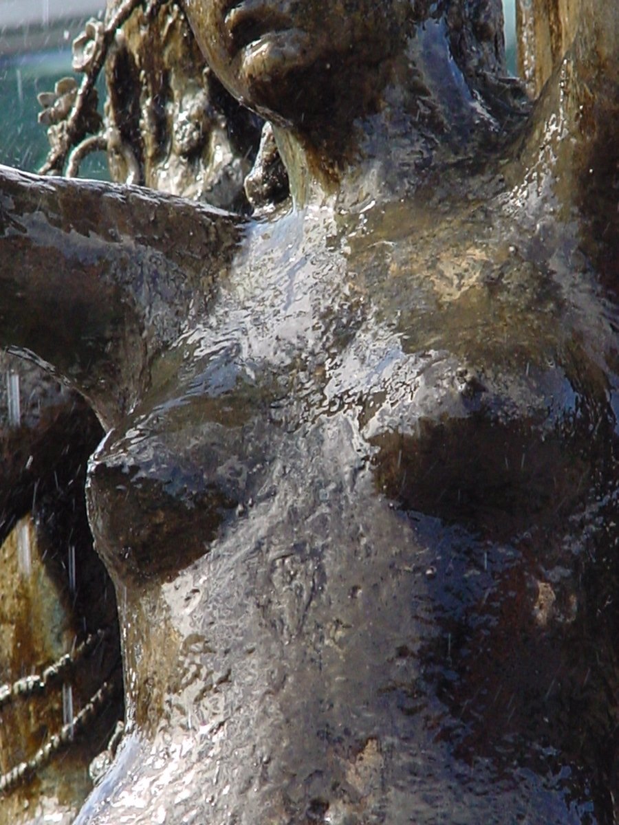 a statue covered in water in front of a building