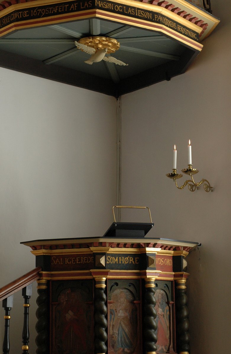 a small church with a pulpit, and two candle chandeliers