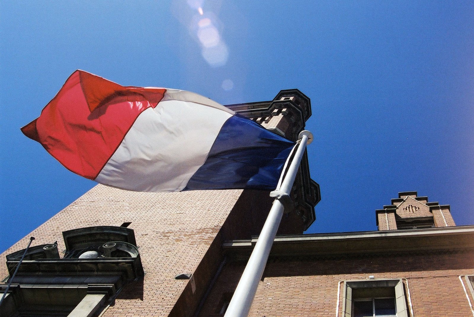 the french flag is flying high on top of a building