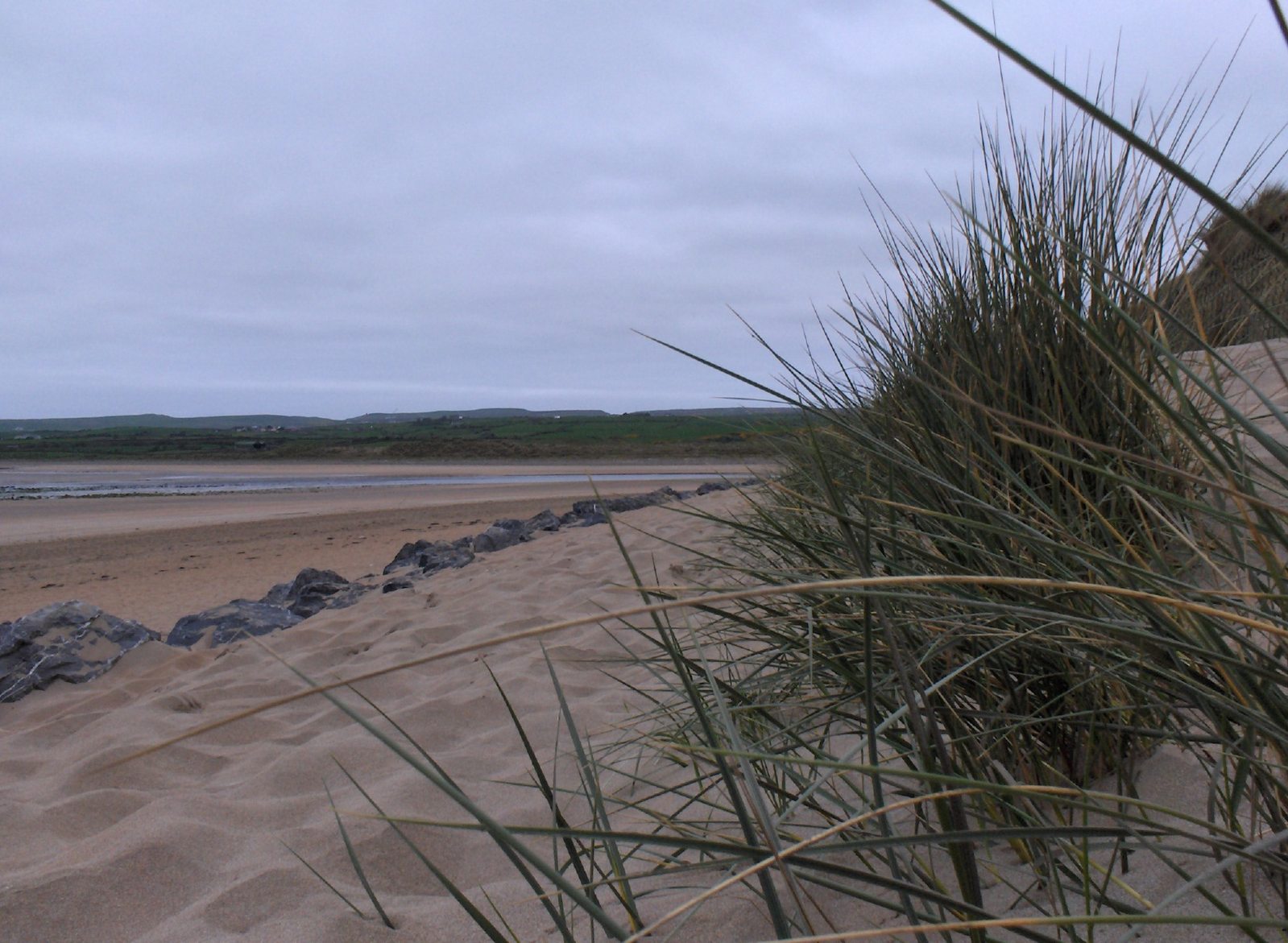 an almost empty beach on an overcast day