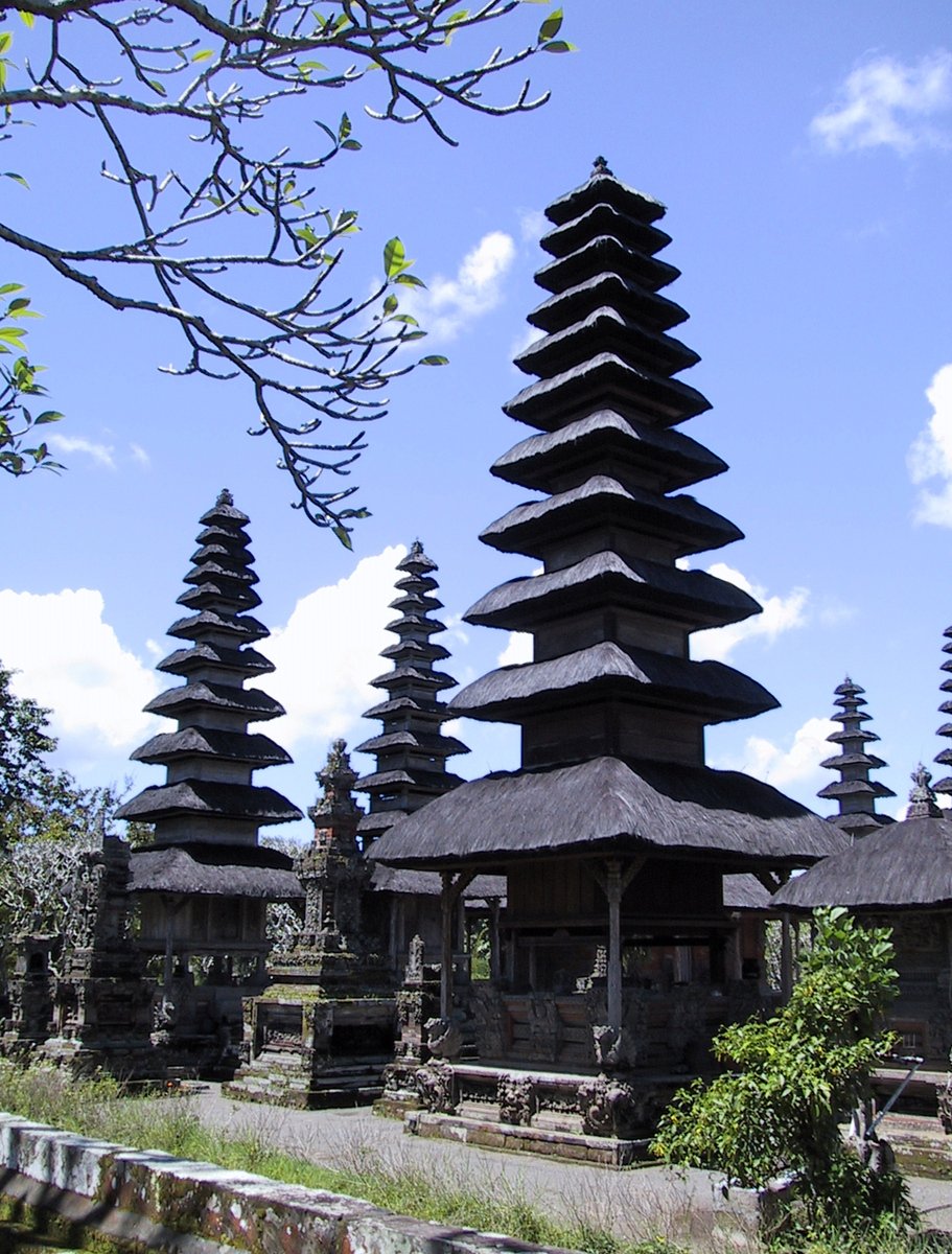 many temple buildings with black stone pillars and trees around them