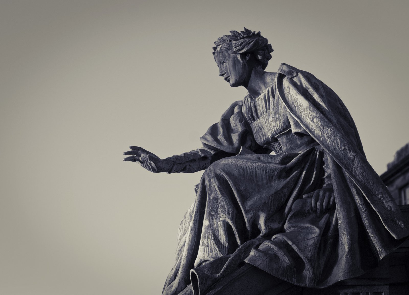 a statue of an person sits on top of a building