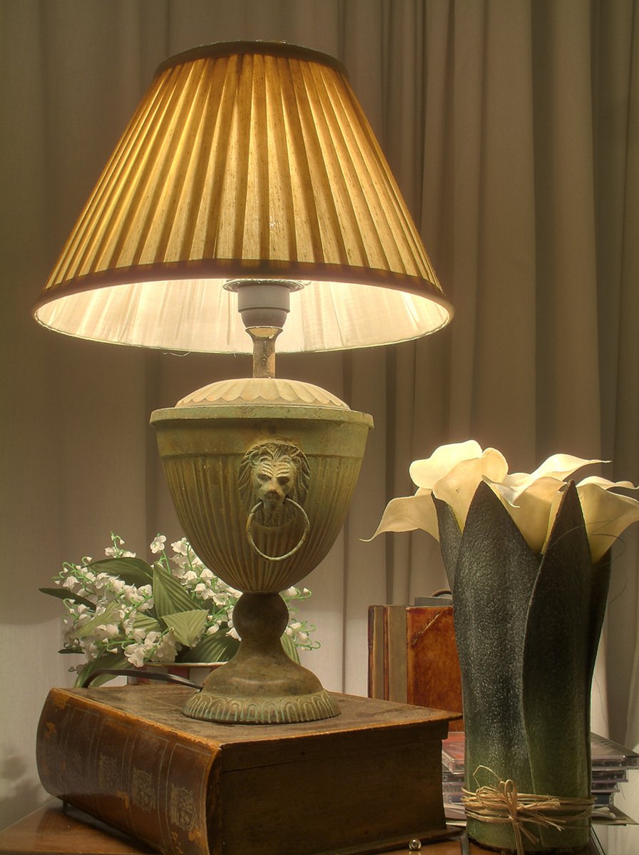 lamp on an old table beside two vases with flowers