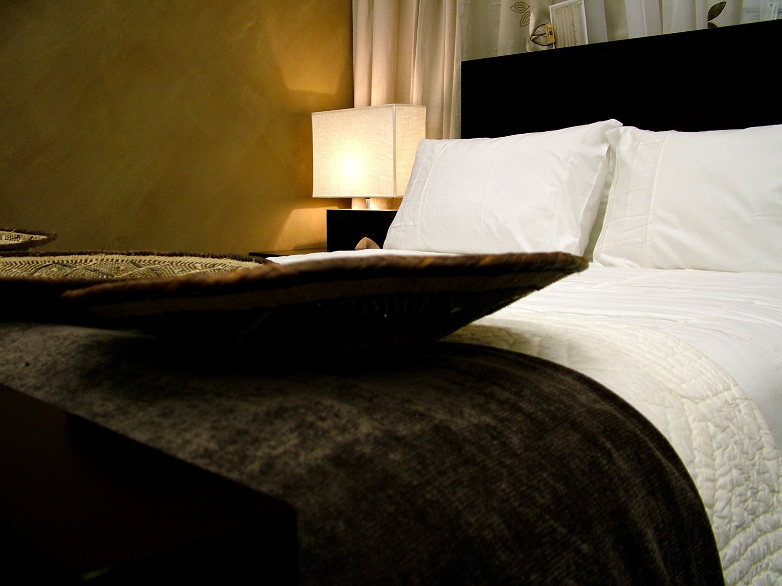 a bed with two pillows and a table with a lamp