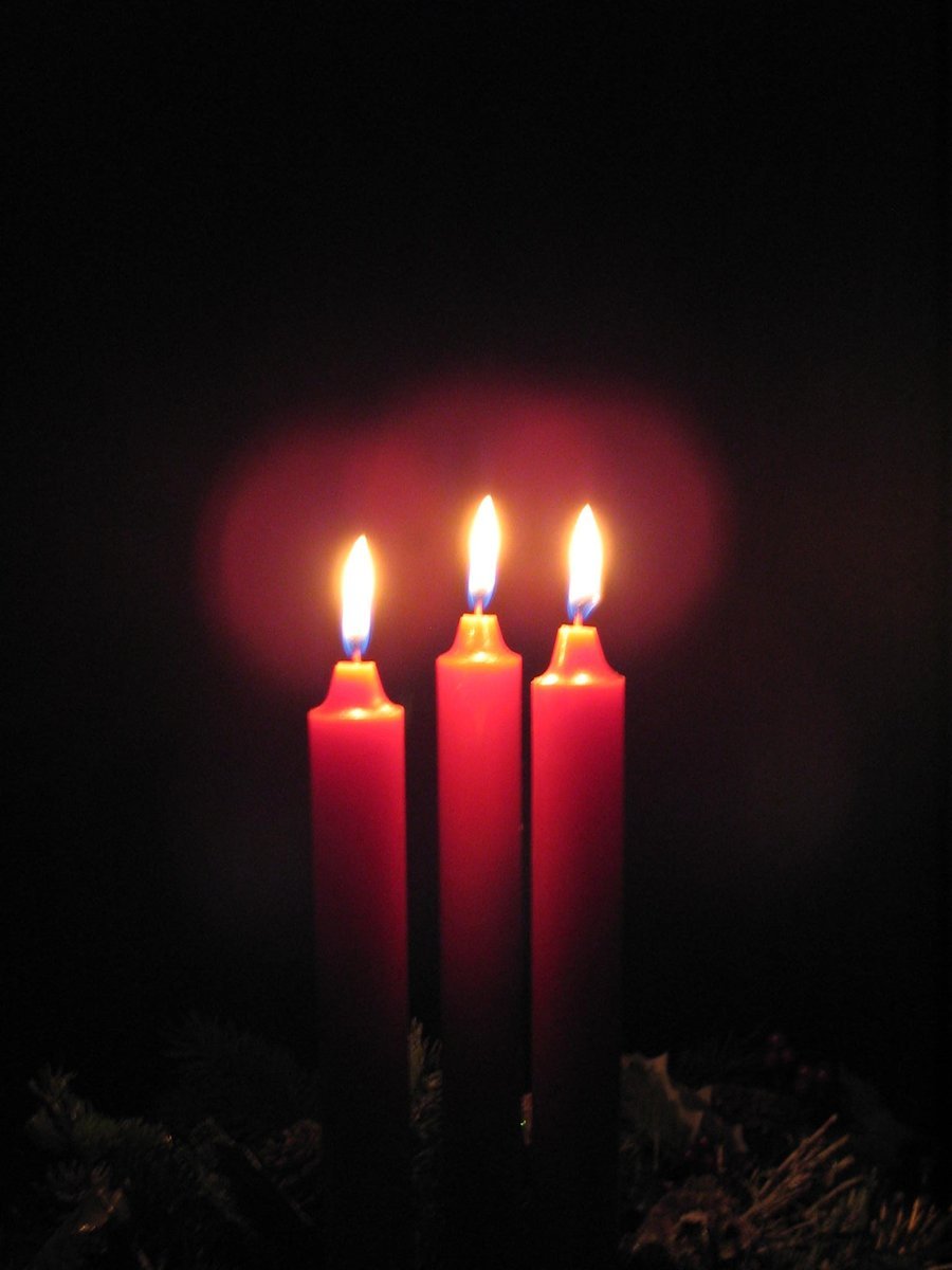 three lit candles sitting on top of a table