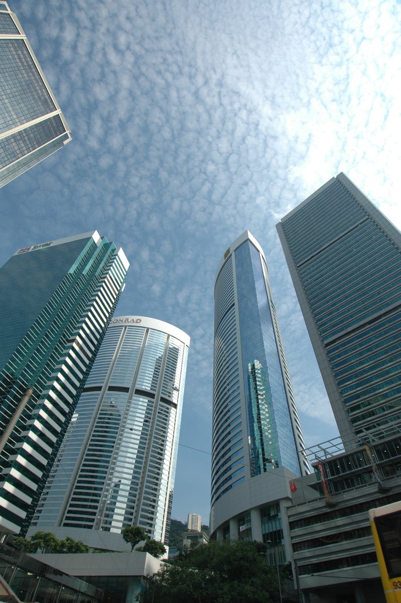 the view of some very tall buildings under a bright blue sky