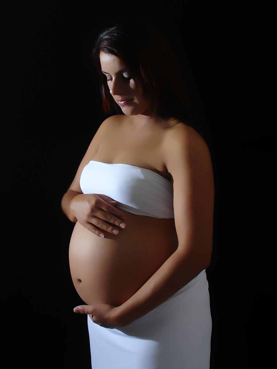 a woman with an over - belly in a white towel