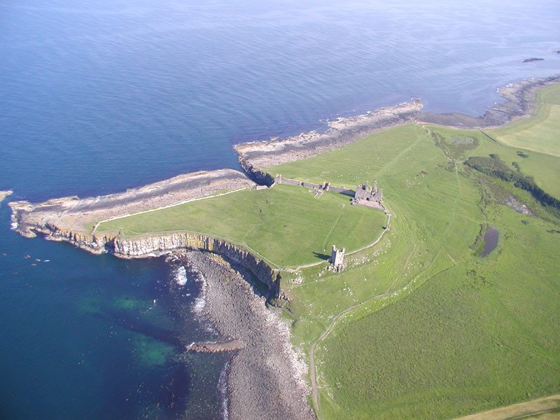 an aerial view of the sea, land and coastline near a rocky coast