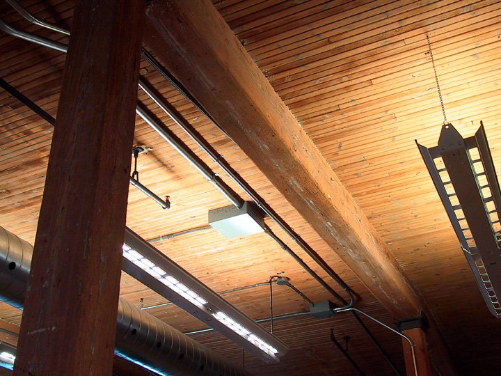 some lights and pipes inside of a wooden building