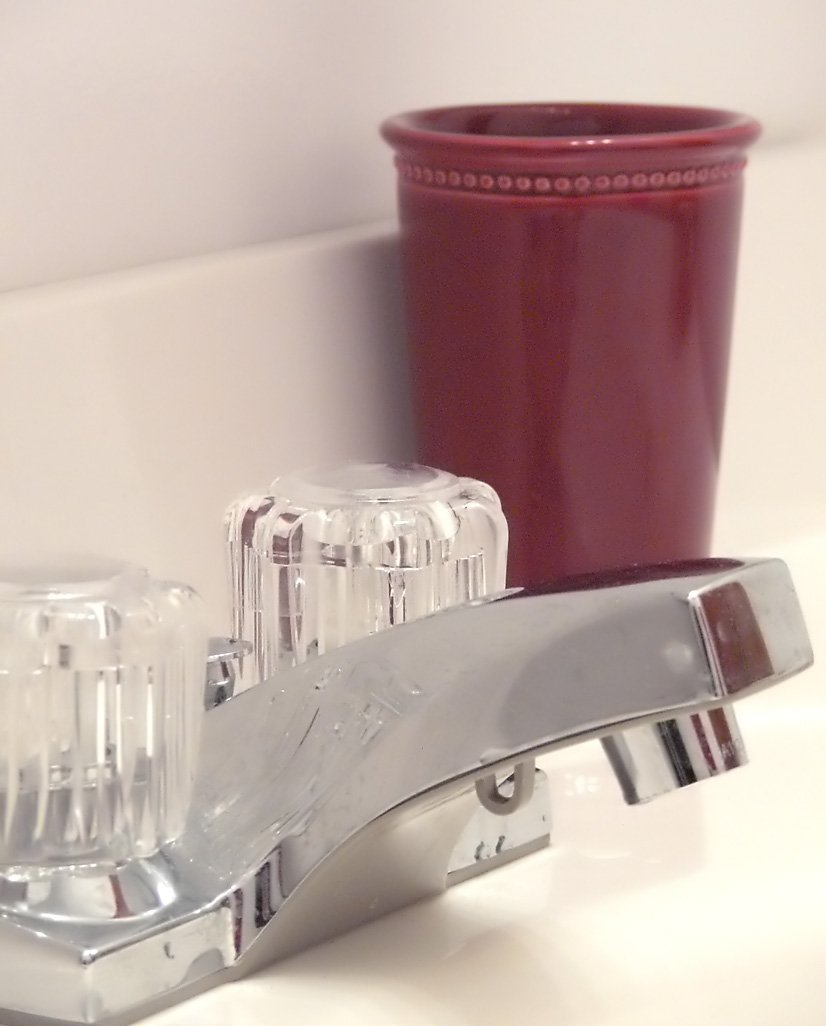 a sink that has a cup and toothbrush holder