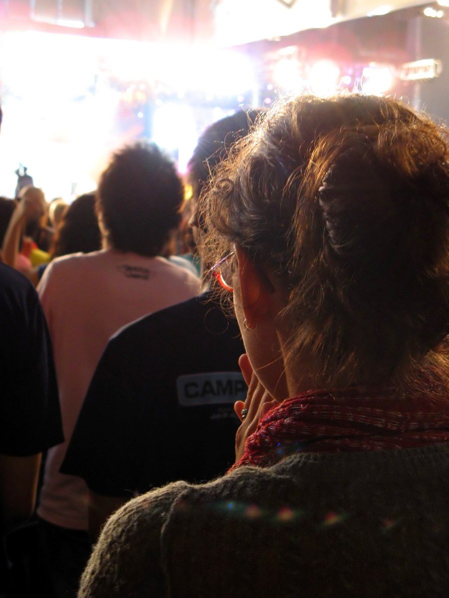 a girl with her head close to the camera at a concert