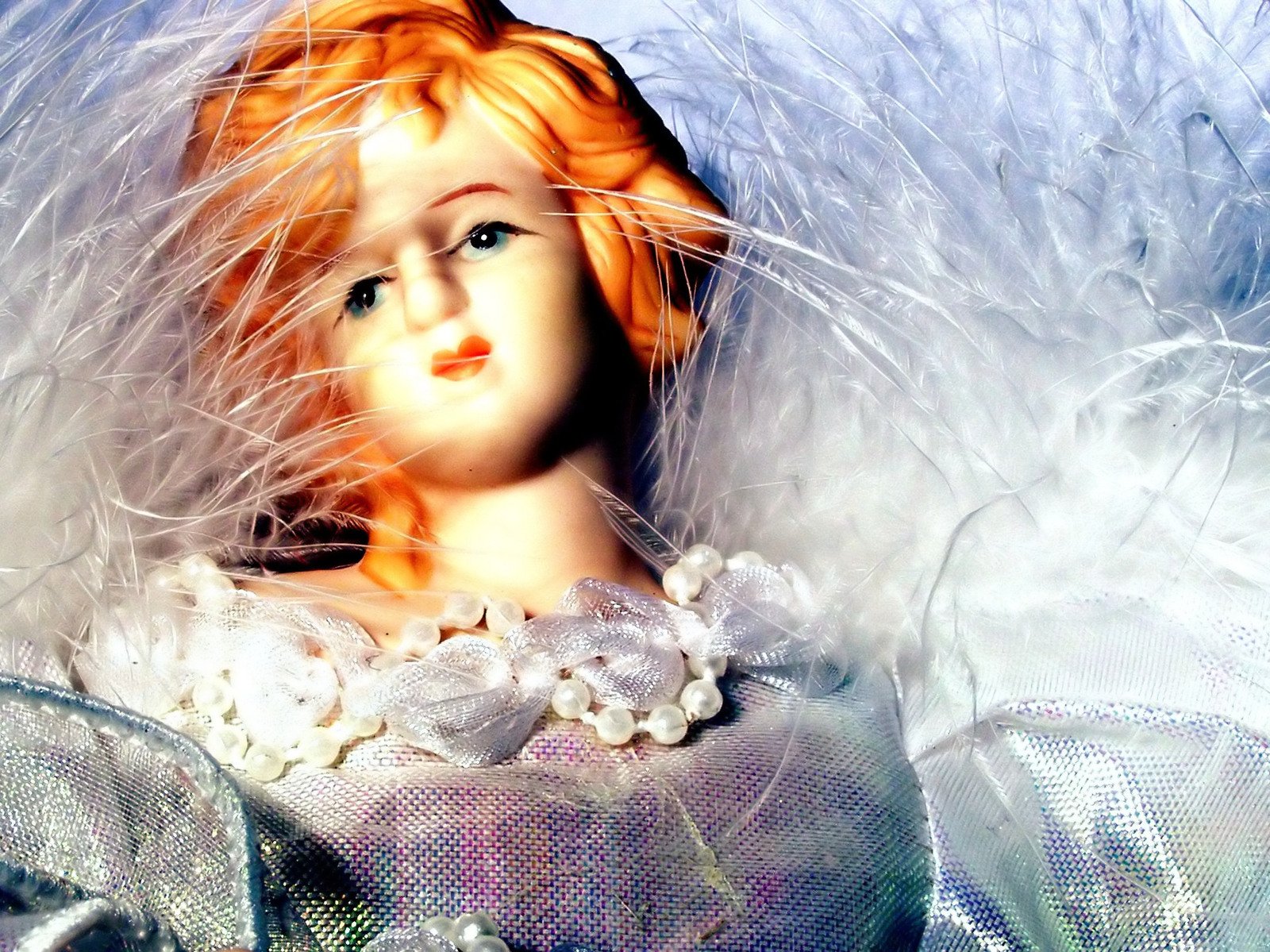 an angel doll with white feathers on her head