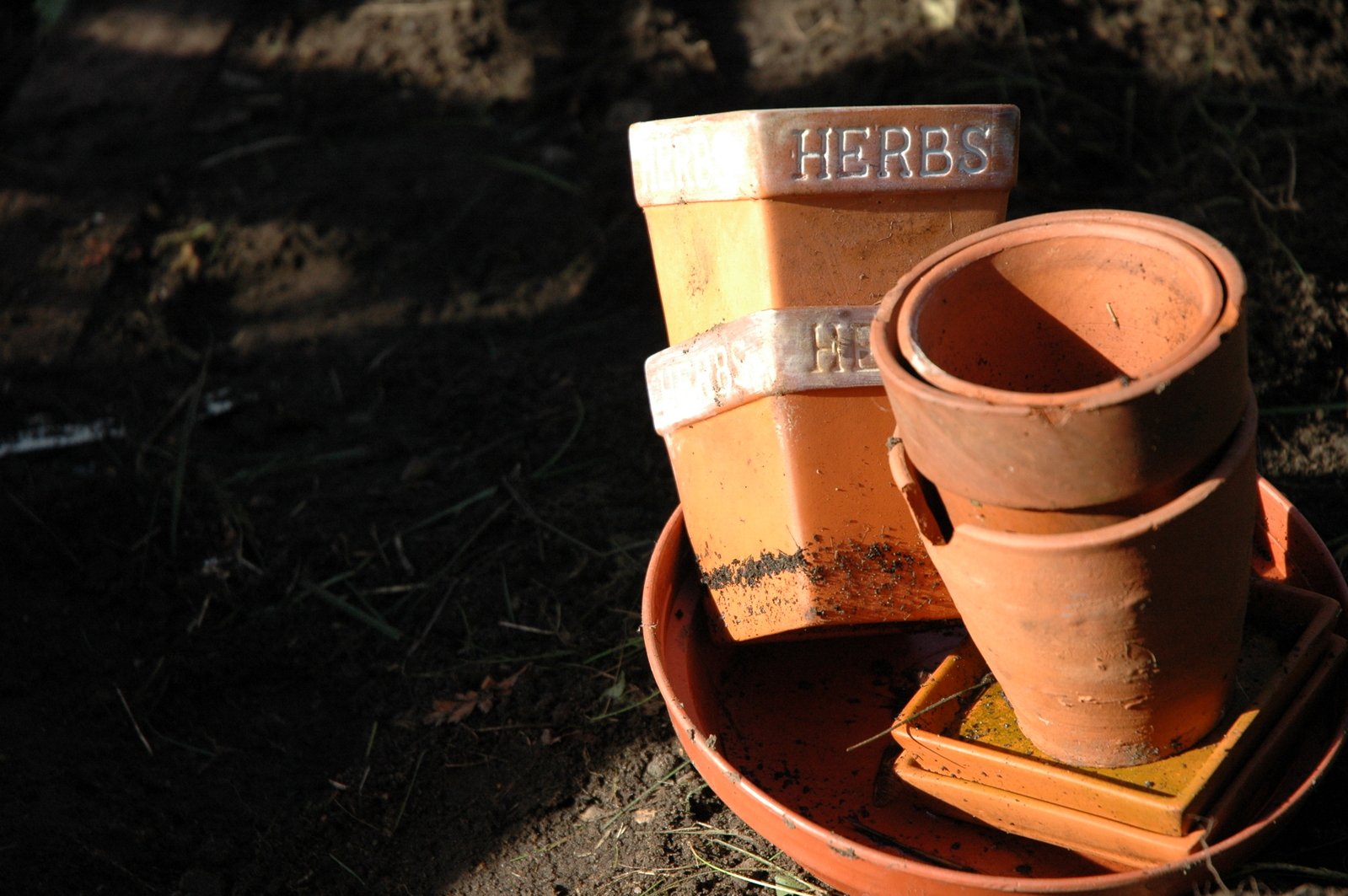 three clay pots and several bricks sitting on the ground