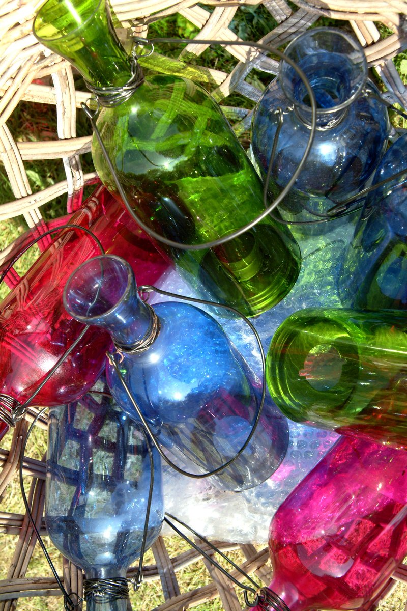 a lot of colorful glasses that are sitting in the grass