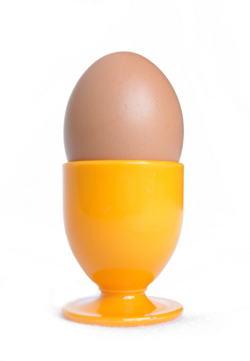 the egg sits in the yellow cup of an egg holder