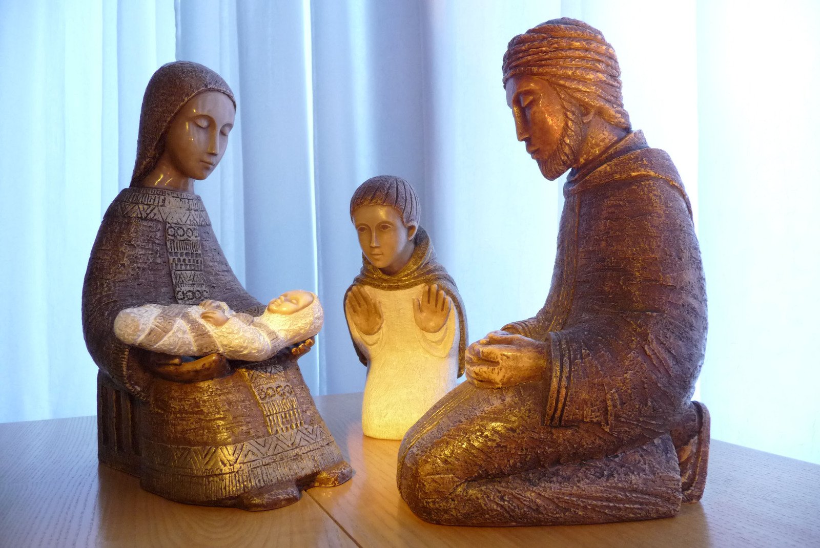 this is two statues of a woman, a baby and a person sitting on a table