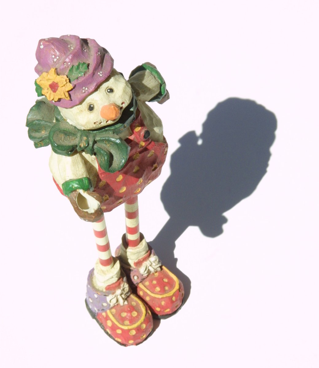 a figurine is shown, the shadow on a white background