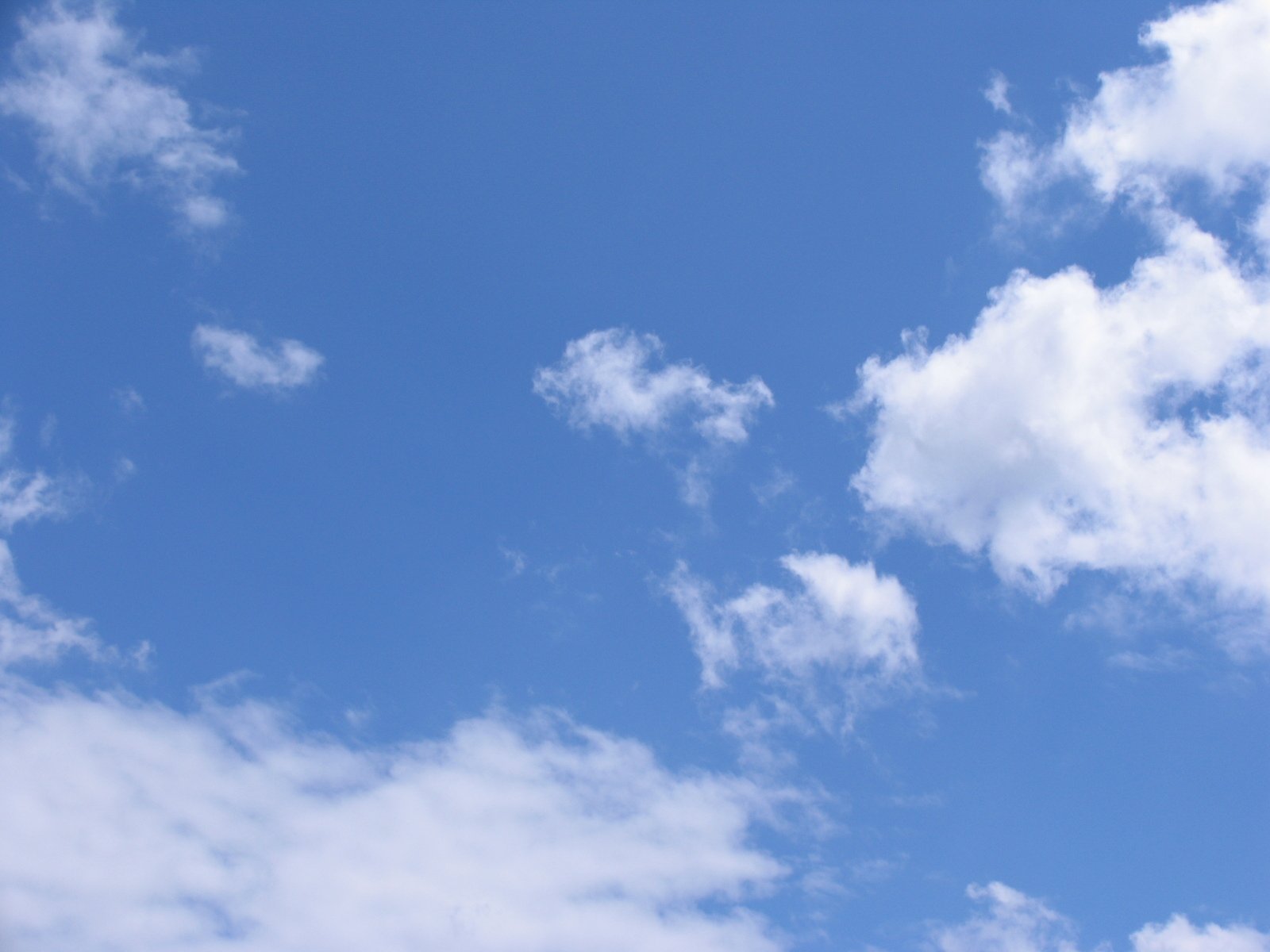 a plane flying high through a cloudy sky