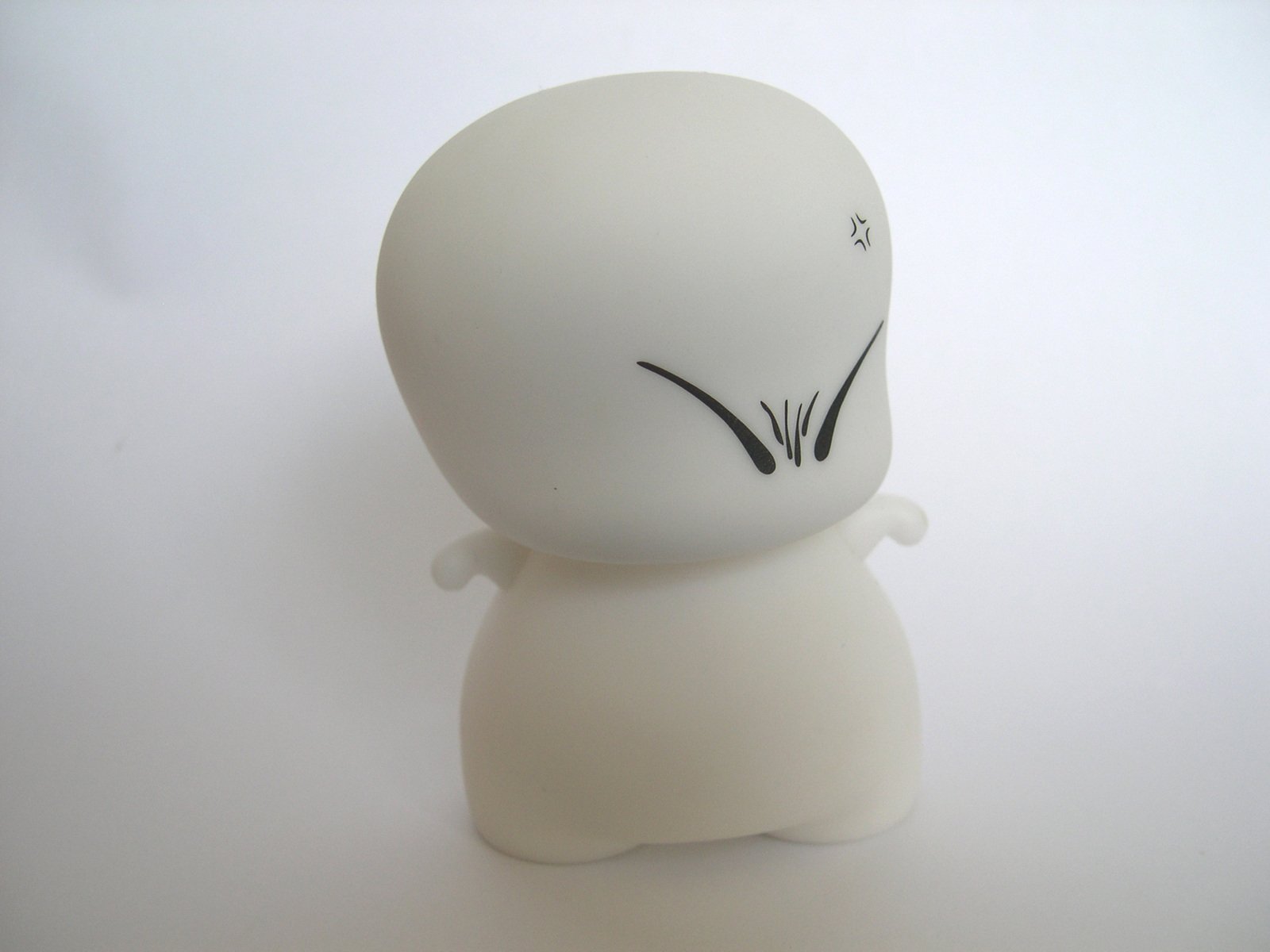 a white faceless, plastic stuffed toy with the eyes closed