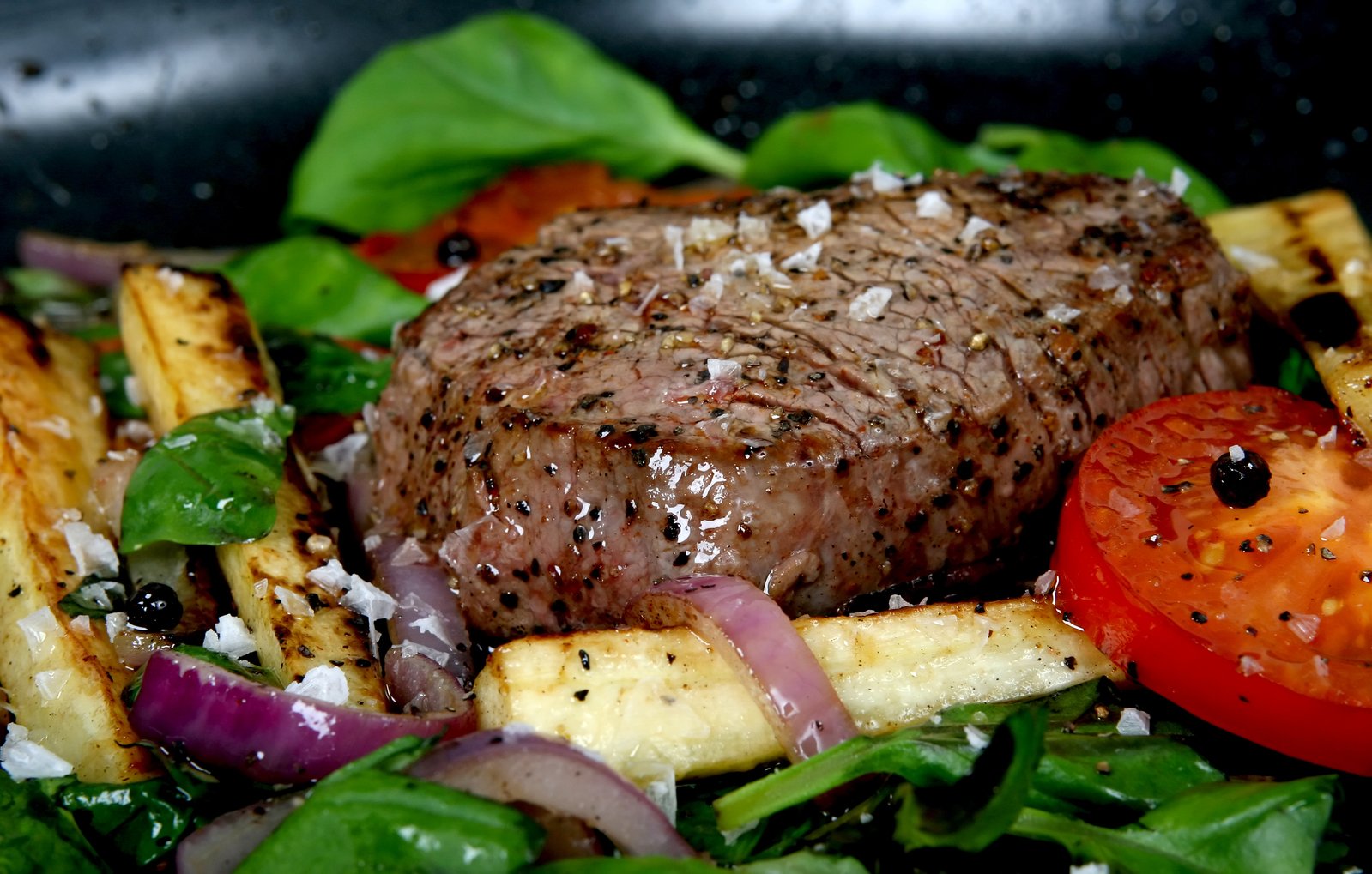 steak, potatoes and tomato on a plate