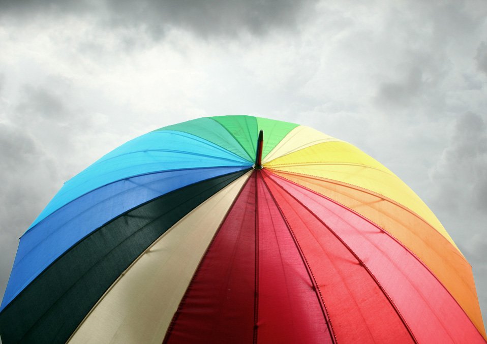 colorful umbrella against a stormy sky with clouds