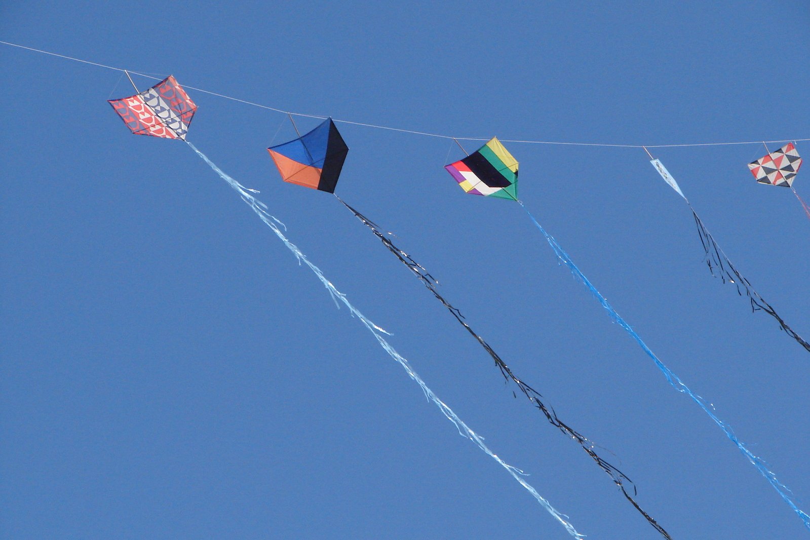 colorful kites flying on a clear day with a blue sky