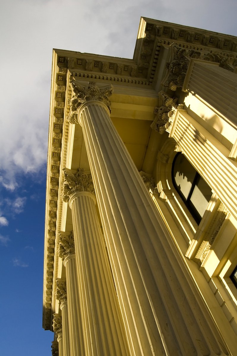 close up of tall building's columns with sky behind