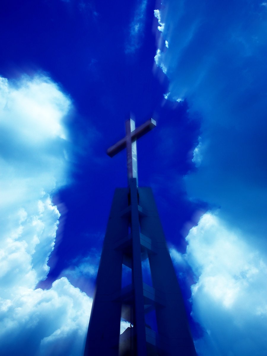 an upward po of a cross and clouds