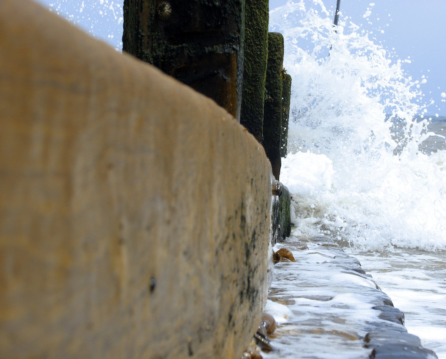 an ocean view with water splashing over the rocks