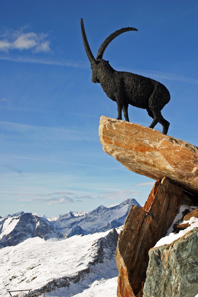 an animal statue on top of a log