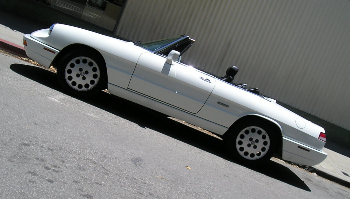 a white convertible parked next to a building