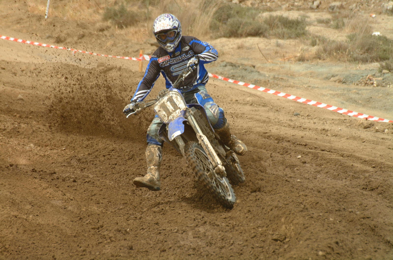 a man riding on the back of a dirt bike across a field