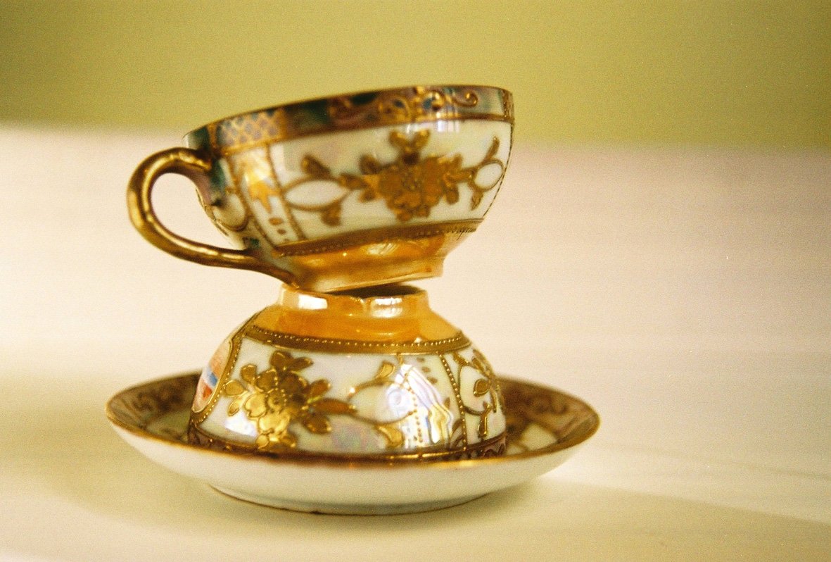 an ornate porcelain tea cup in golden color