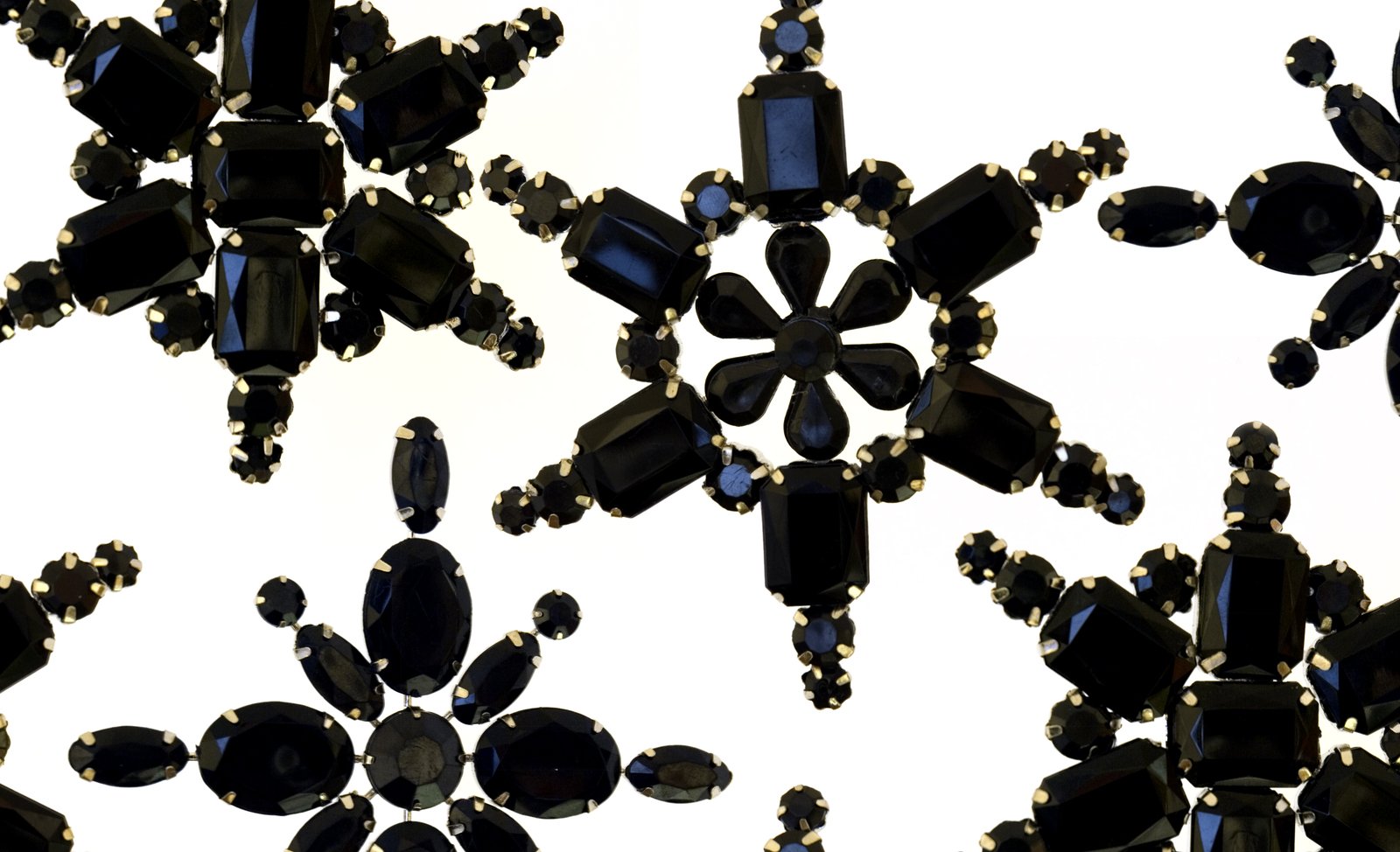 black glass decorations and black beads are on a white background