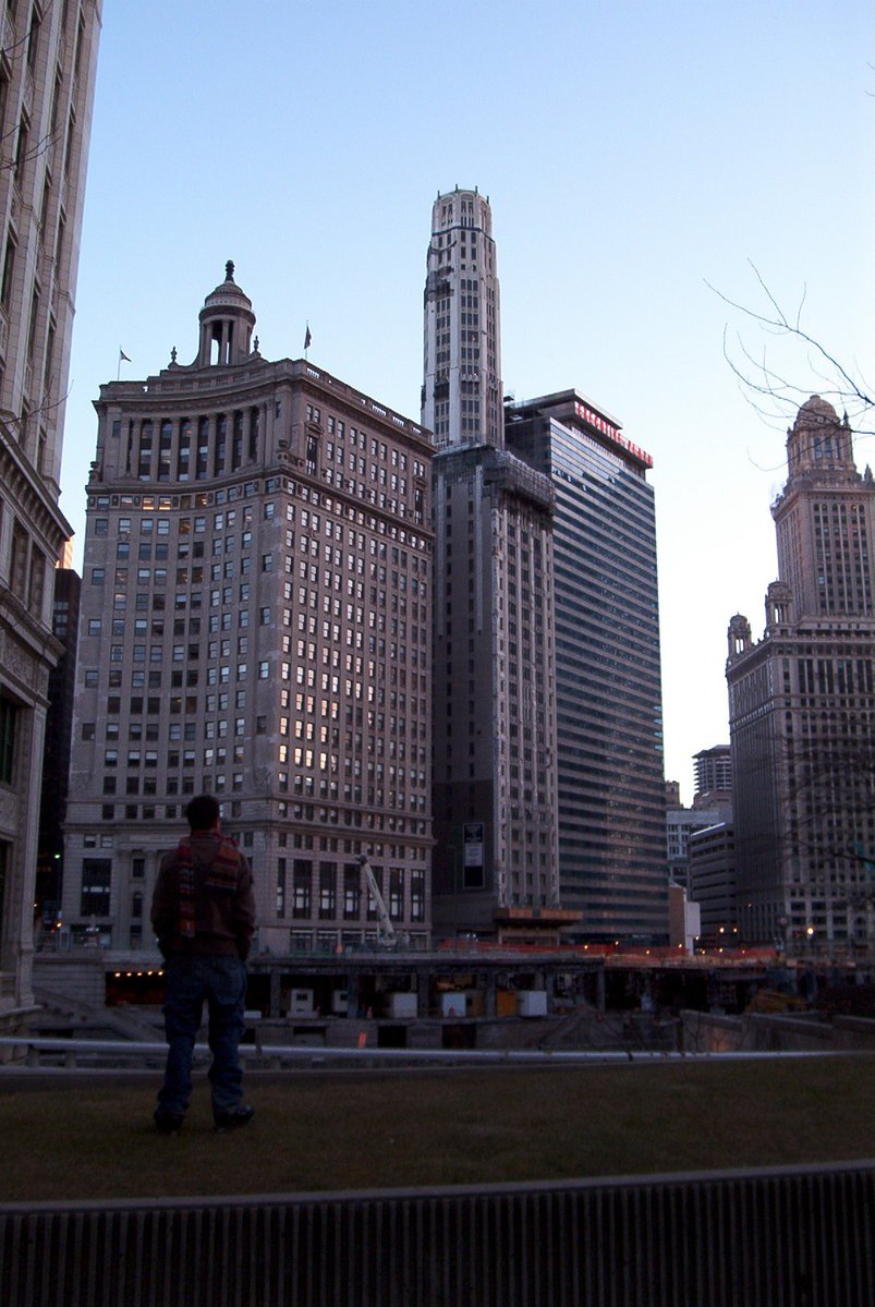 a man standing near a city with lots of tall buildings