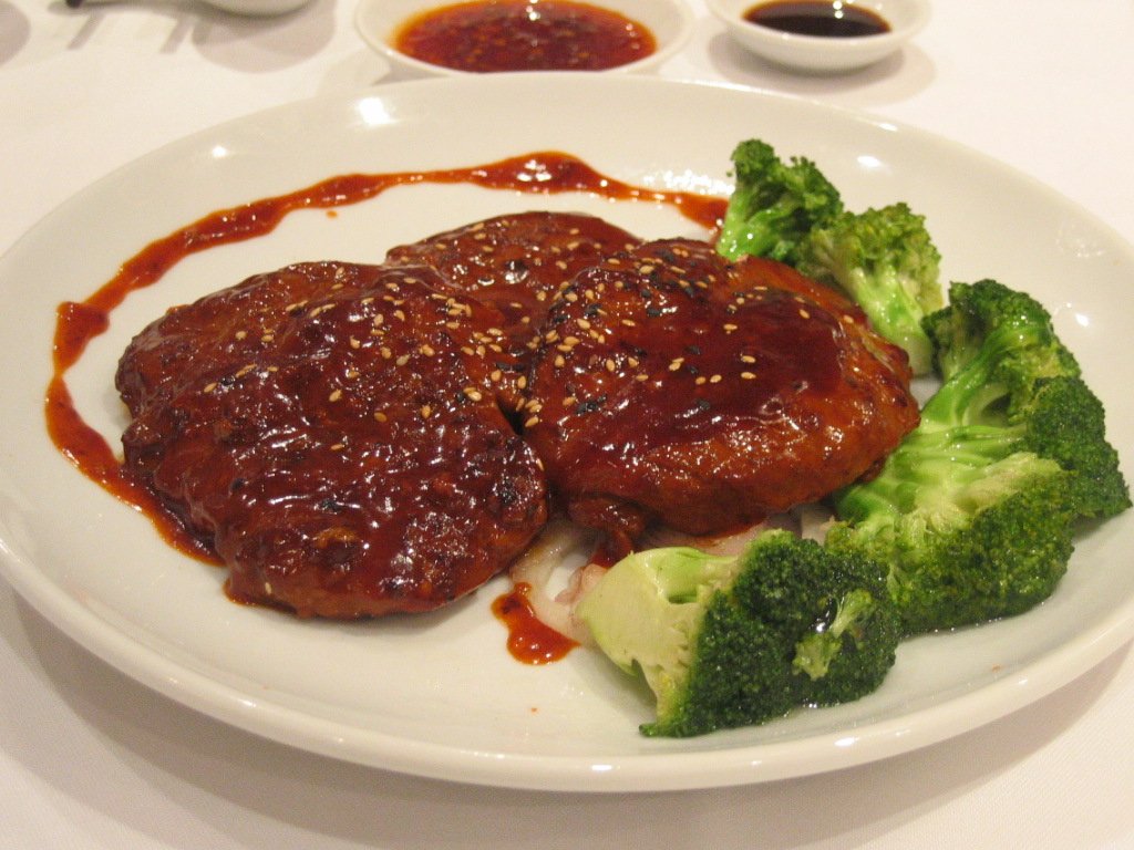 a white plate topped with a meat covered in sauce