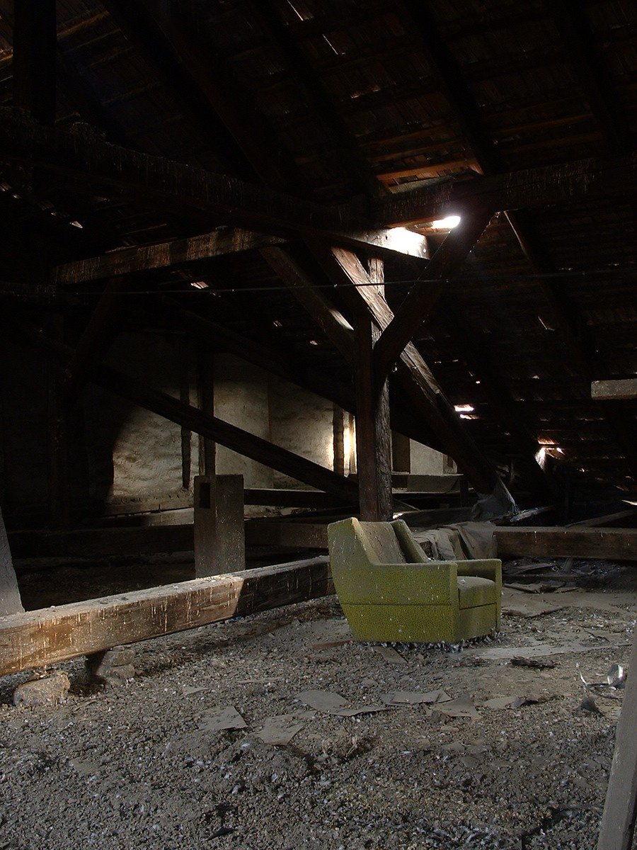 an old building has benches, tables, and a couch