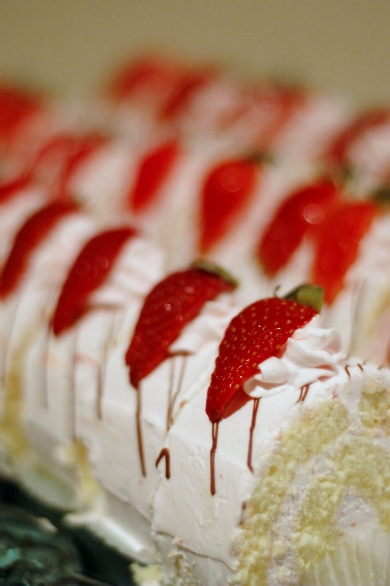 closeup of a sliced cake with strawberries on top