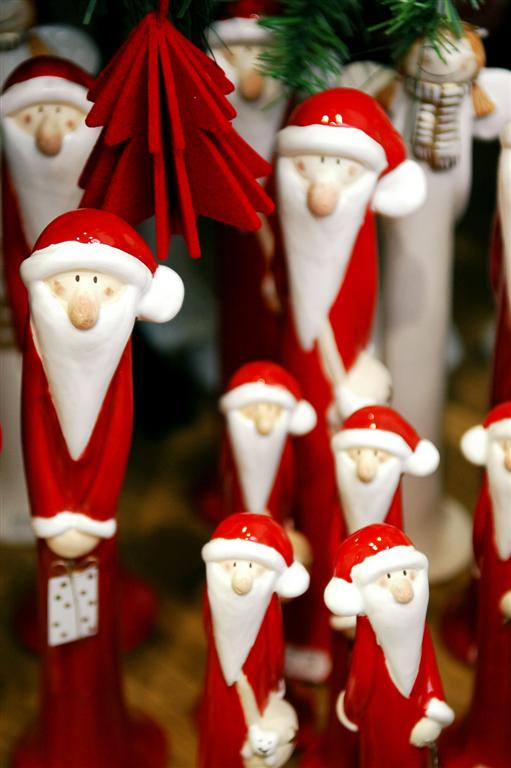 an array of christmas ornaments in santa's clothes and bows