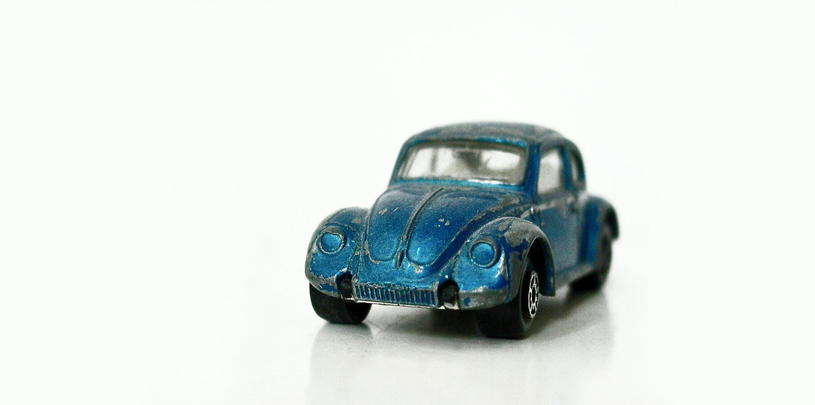 a blue toy car sitting on top of a white surface