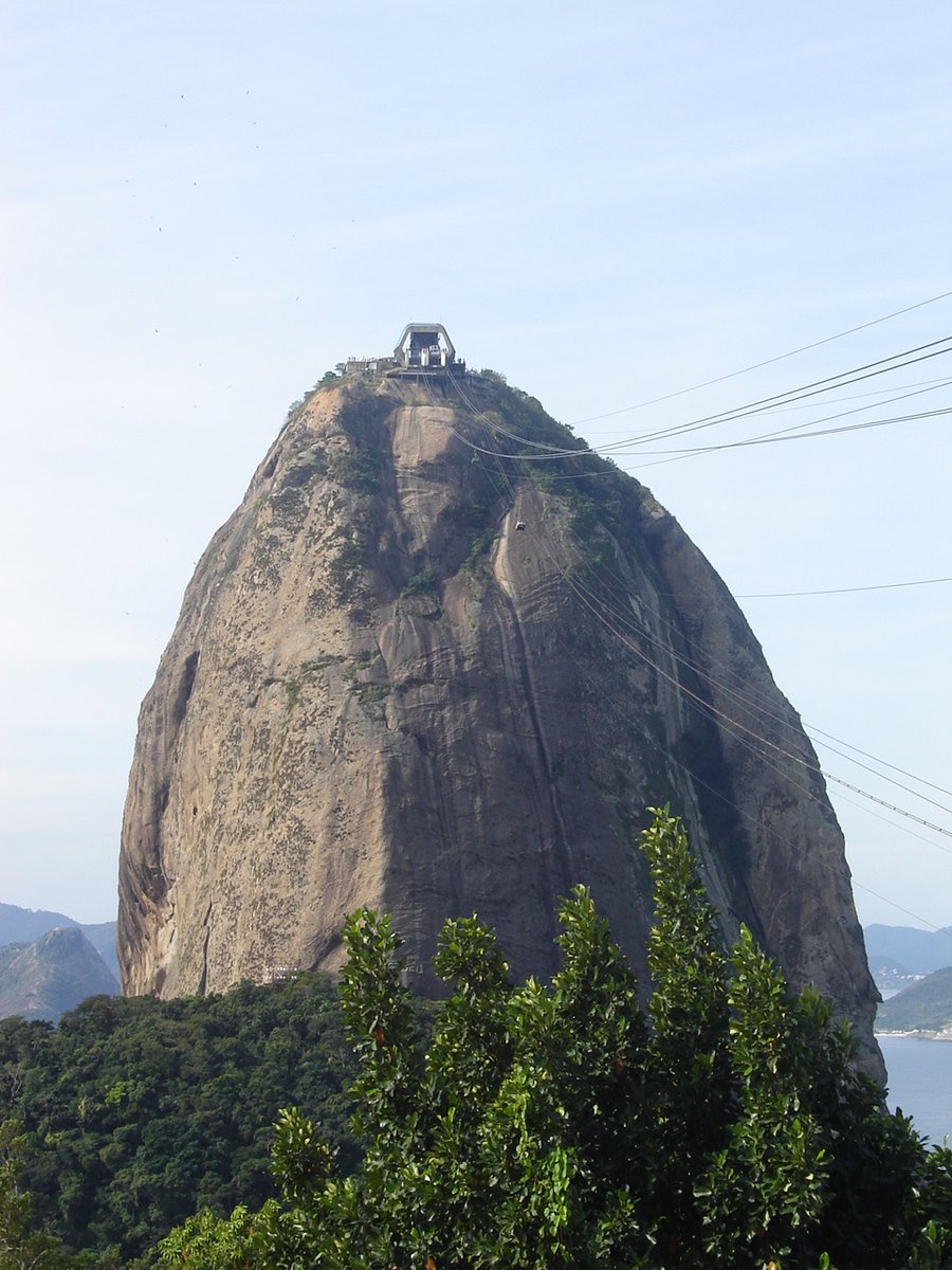 a big rock out on the hill with people standing on it