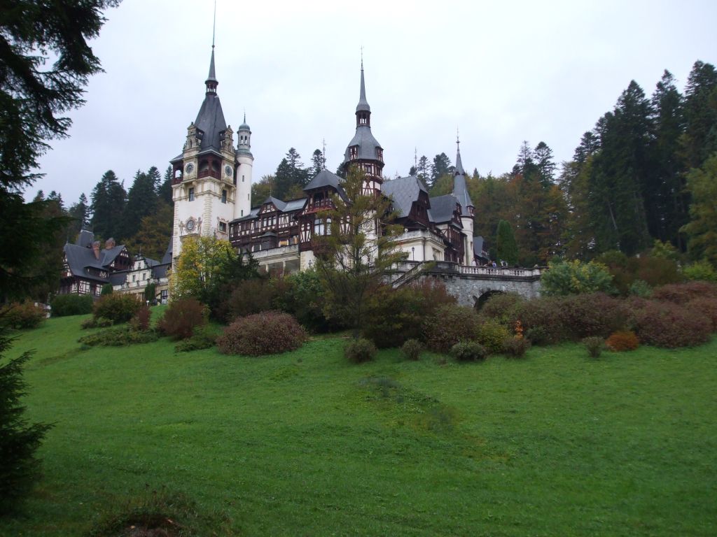 an old castle sits on a hill above some trees