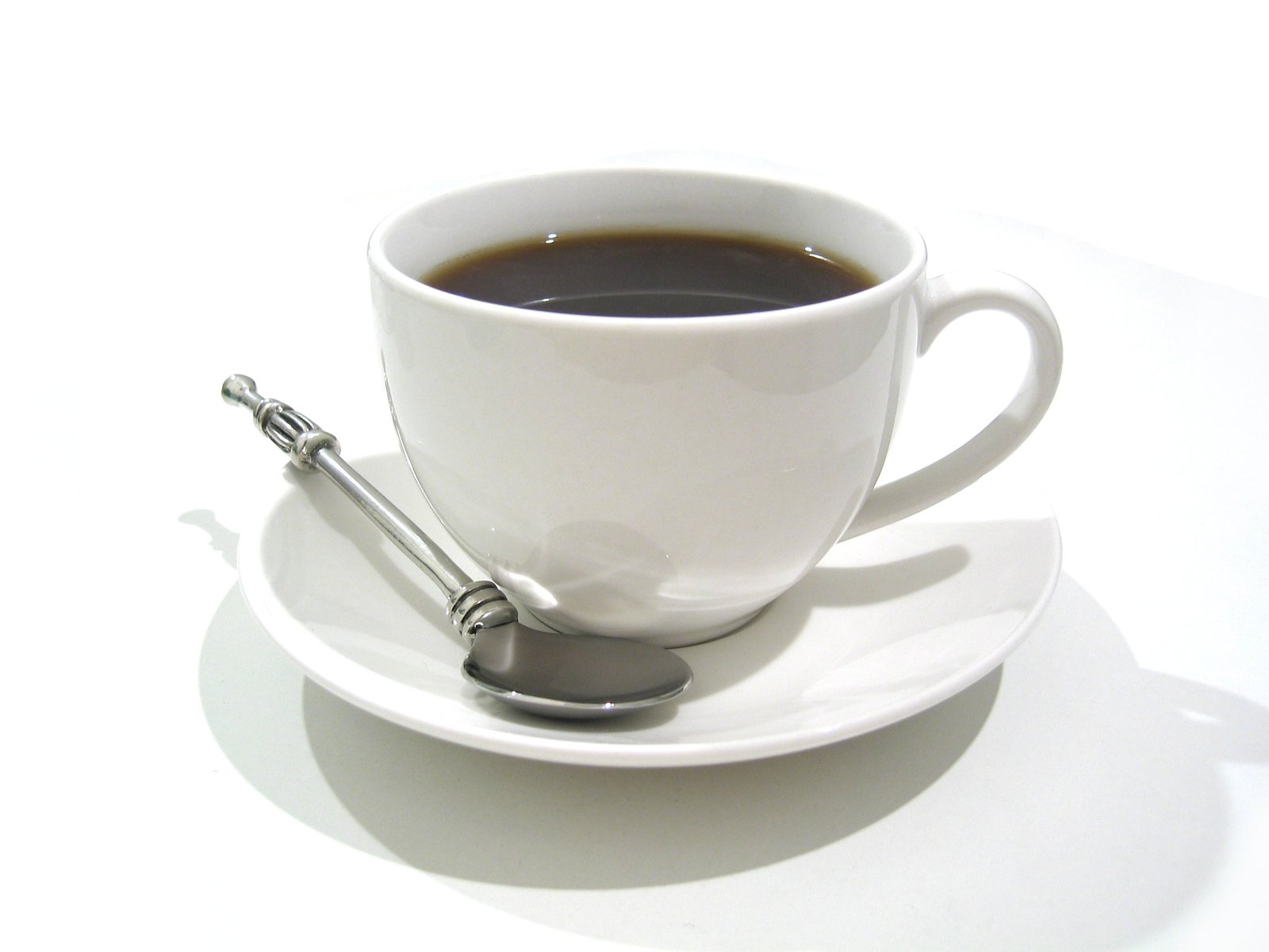 a cup with coffee and spoon on the saucer