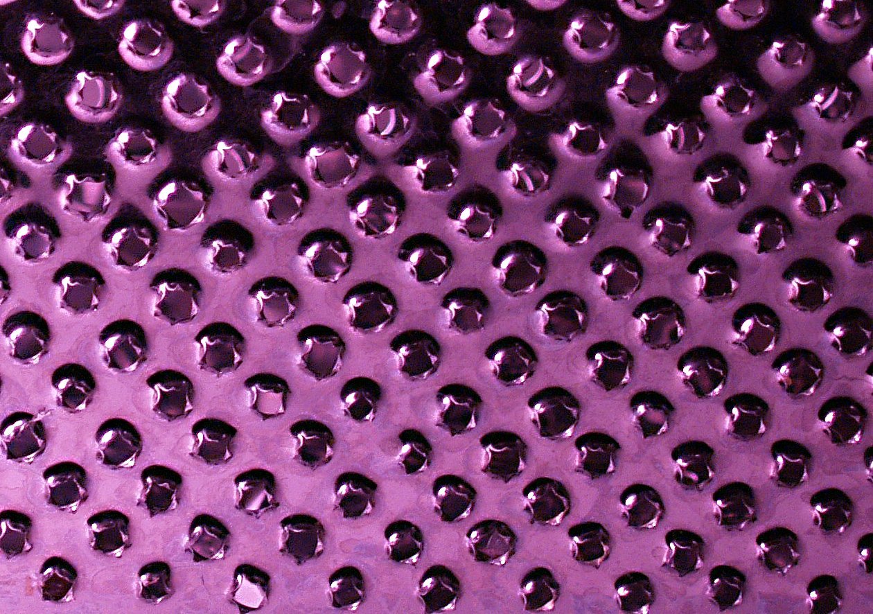 close up po of water drops on purple plastic sheet