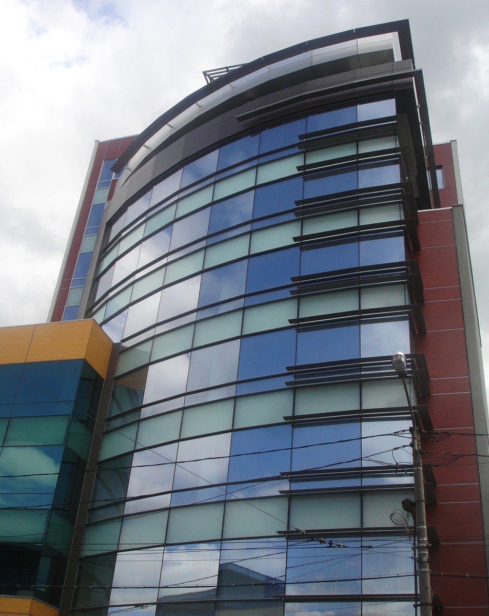 a modern building features many windows, along with a bright orange building