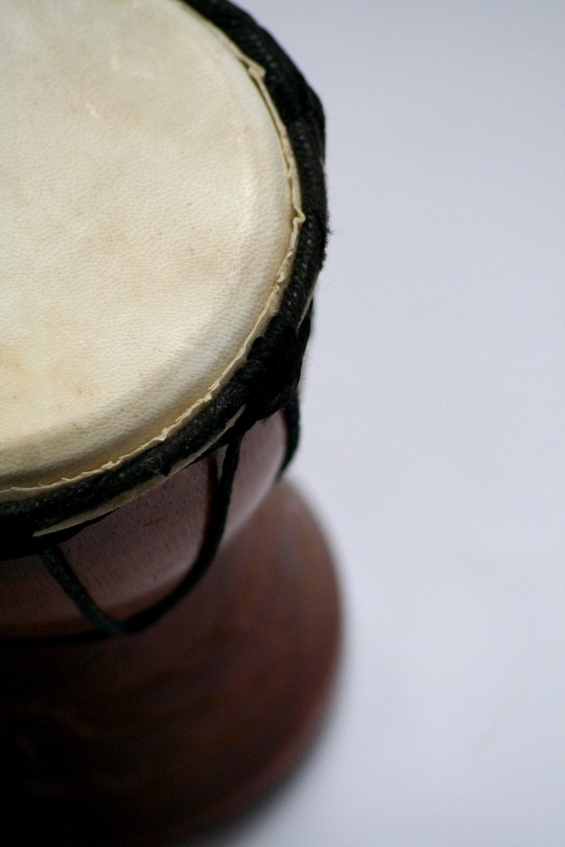 a brown and black drum sitting on top of a white table