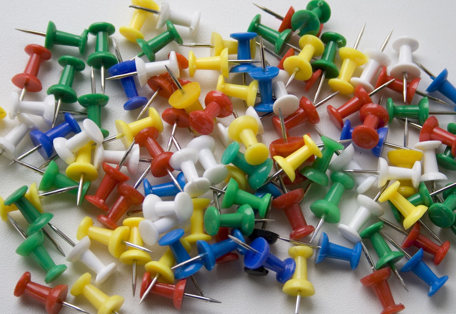 small assortment of colorful plastic pins on white surface