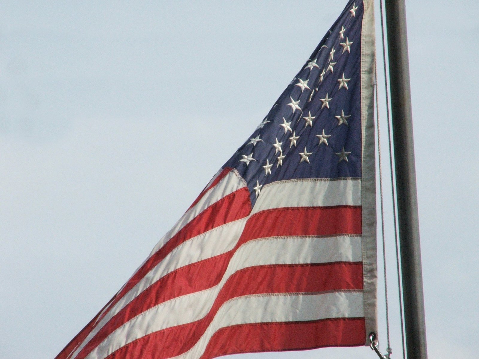 the american flag is hanging from the pole