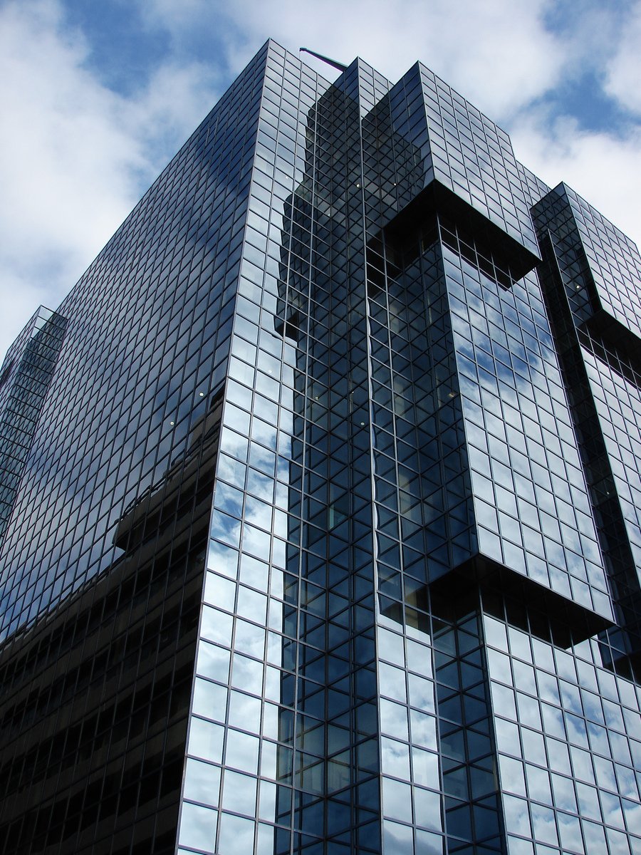 tall black glass buildings against a blue cloudy sky