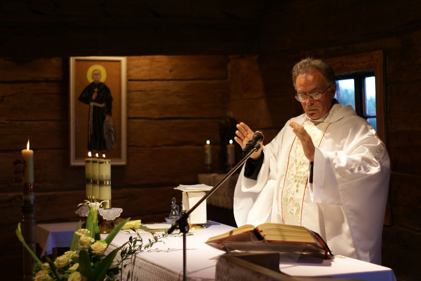 the priest is standing at the alter with his hands in prayer